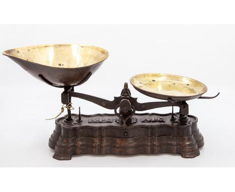 A late Victorian/Edwardian set of cast iron and brass kitchen scales, of lobed rectangular form with scroll-form balance, the