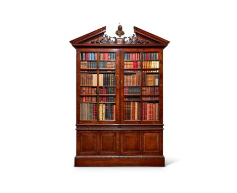 A George II style mahogany library bookcase, the broken arch pediment with egg and dart mouldings and a central platform for 