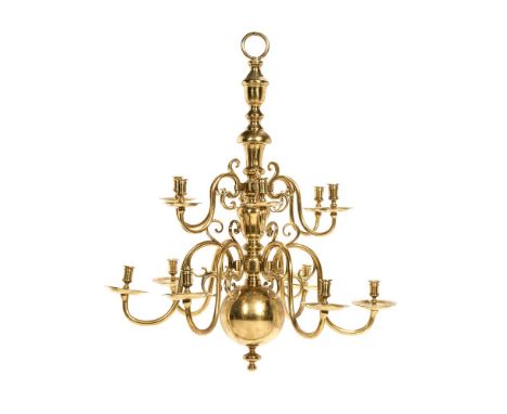 A brass twelve light chandelier in 17th century Dutch style, 20th century, the scrolled arms arranged in two tiers around a k