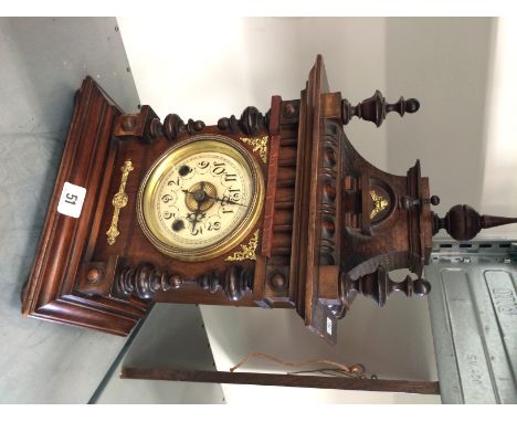 An oak cased Gothic style mantle clock with circular dial.