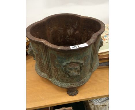 A cast iron oviform planter decorated with lions masks resting on three paw feet (one missing).