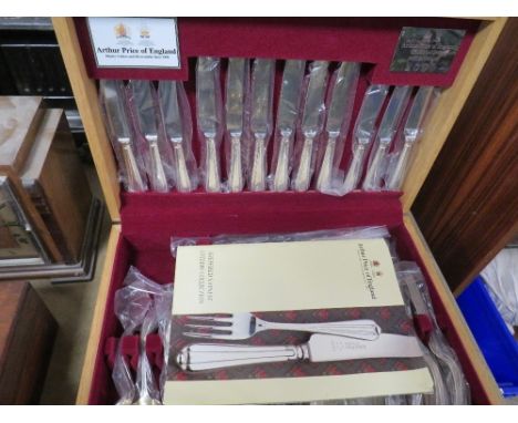 An unused Arthur Price Millennium canteen of cutlery in light oak effect box (unchecked)