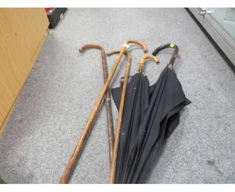 A selection of vintage walking sticks and umbrellas