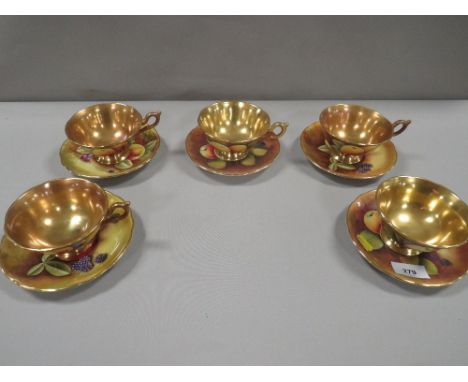 Five Coalport orchard gold cups and saucers with gilded interiors