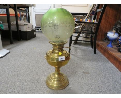 A vintage brass oil lamp together with a green etched shade