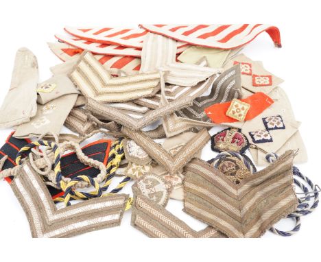 A quantity of British army lanyards, swallows' nests, rank insignia etc