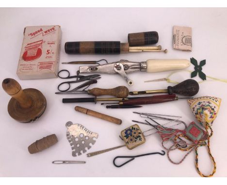 A collection of antique and vintage sewing implements including button hole scissors, a darning mushroom, needle cases etc