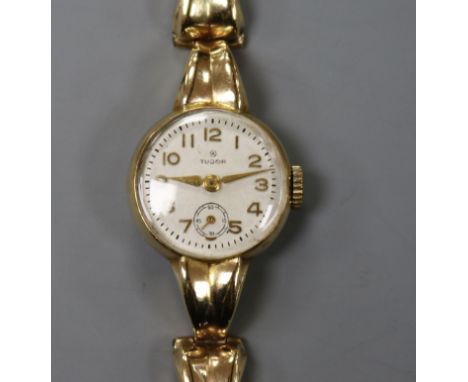 A lady's 9ct gold Tudor manual wind wrist watch, on a 9ct gold bracelet.