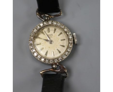 A lady's 1960's 9ct white gold Tudor manual wind wrist watch with diamond set bezel, with associated leather strap.