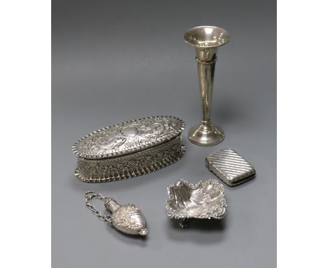 A late Victorian repousse silver trinket box, a silver spill vase, silver salt, silver vesta case and a scent flask.