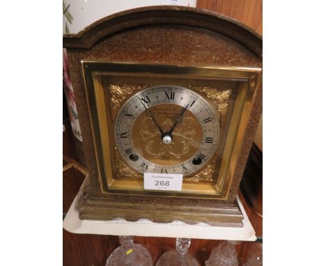 A WOODEN CASED ELLIOTT MANTLE CLOCK RETAILED BY GARRARD AND CO LIMITED WITH KEY AND BOOKLET 