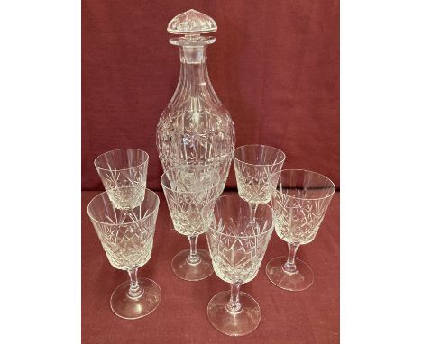 A heavy cut crystal decanter together with a set of cut glass stemmed glasses.  