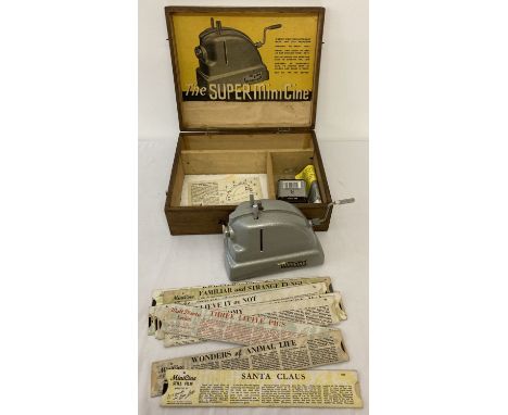 A vintage "The Super minicine" film projector with original slide strips by Martin Lucas Ltd. Complete with wooden box and in