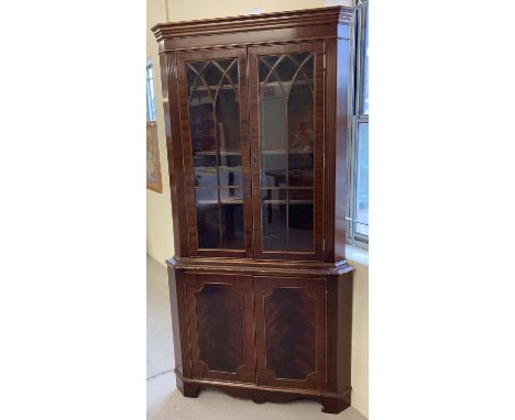 A large reproduction mahogany corner unit with glass doors and interior shelves to top. Two door cupboard with interior shelf