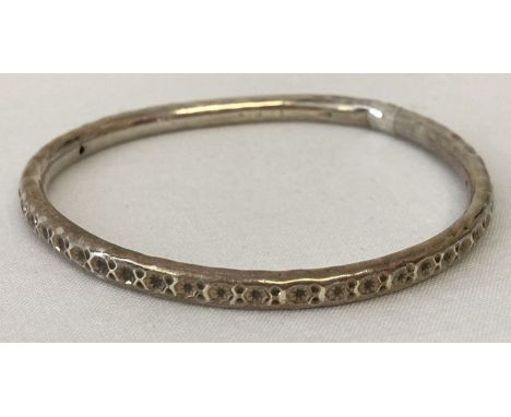 A silver bangle with punched star decoration. Very worn hallmarks, bangle has been altered.  Total weight approx. 8.2g.