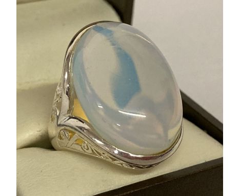 A 925 silver dress ring set with large opal glass cabochon &amp; with pierced work detail to shoulders.  Ring size P½, stone 