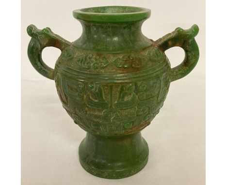 A Chinese jade 2 handled urn with Archaic design carved detail.  Approx. 17.5cm tall.