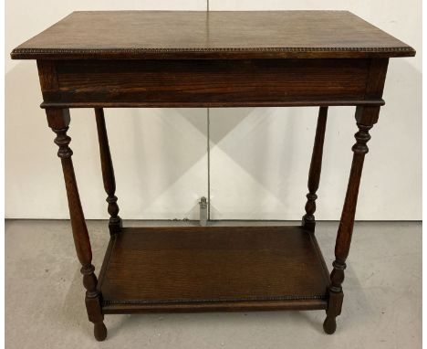 A vintage oak side table with lower shelf, turned legs and beaded detail to top.  Approx. 68 x 38 x 75cm.