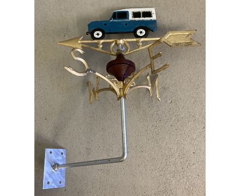 A painted cast metal weather vane with Land Rover detail finial. With wall fixing bracket. Approx. 56cm tall.