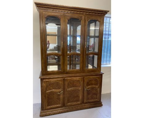 A large mirror backed, solid wood display unit with glass doors and cupboard base. Base has interior shelf and one small draw