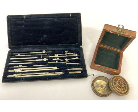 A boxed set of scientific instruments together with a boxed modern brass cased compass advertising Jacko boot polish. 