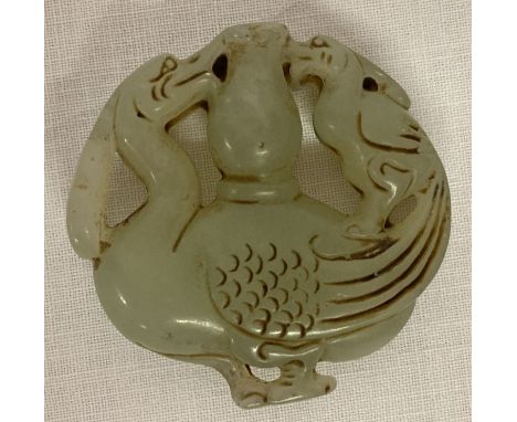 A Chinese Jade roundel depicting carved Phoenix detail to both sides.  Approx. 5.5cm diameter.