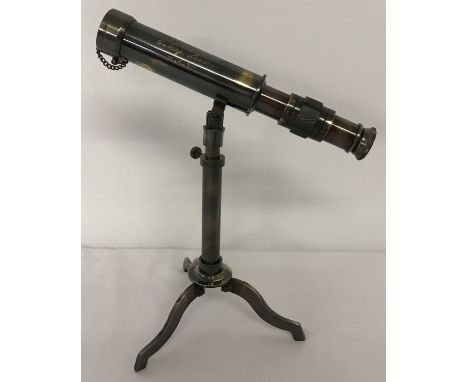 A small brass telescope mounted on an extending tripod base with folding feet. Telescope body is marked "W Ottway &amp; Co Lt