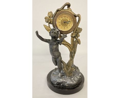 A vintage Art Nouveau style table/mantle clock with cherub figure and iris flower decoration. On a circular marble base. 