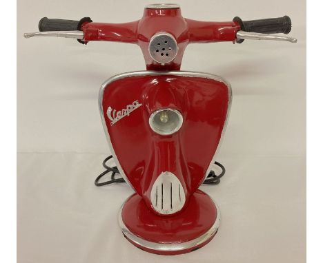 A novelty table lamp in the shape of the handlebars of a Vespa scooter, in dark red. With moving brake levers and speedometer