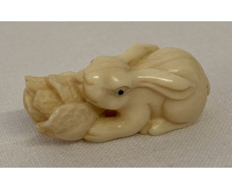 A small signed Netsuke carved into the form of a rabbit with a cabbage. Signature on underside. Approx. 1.5cm x 3.5cm.