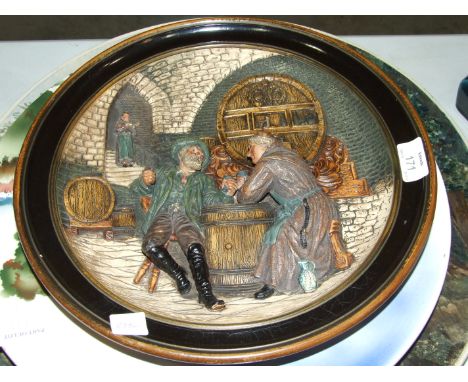 A Musterschutz painted relief-decorated pottery plaque depicting monks in a wine cellar, 34cm diameter, a moulded pottery bra