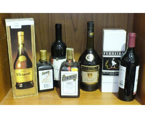 A bottle of Bisquet Cognac, a bottle of Martell Cognac and other bottles.