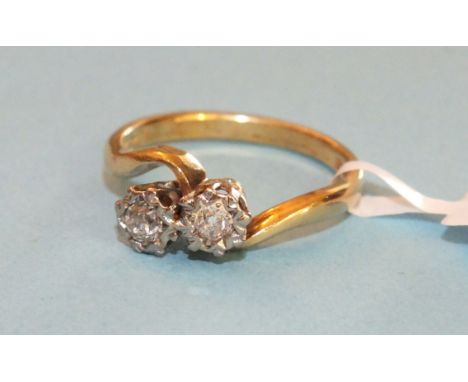 A diamond cross over ring set two brilliant cut diamonds in 18ct gold mount, size M, 3.6g.