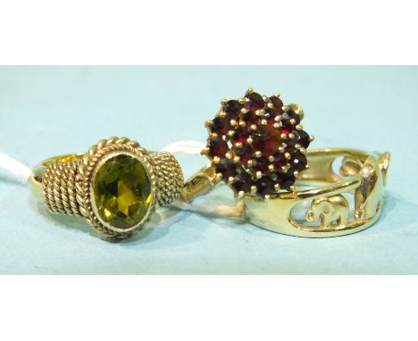 A 9ct gold ring incised with an elephant design, size M, 3.3g, a garnet cluster ring and another ring, (3).