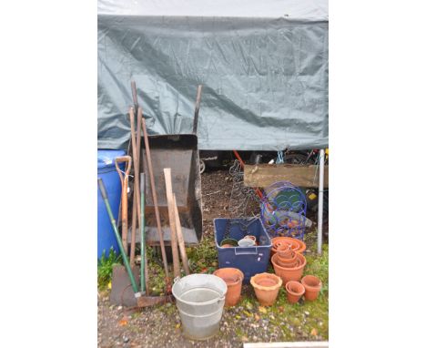 A SELECTION OF GARDEN TOOLS AND ORNAMENTATION, to include a builders wheelbarrow, garden hand tools, galvanised bucket, 30+ m