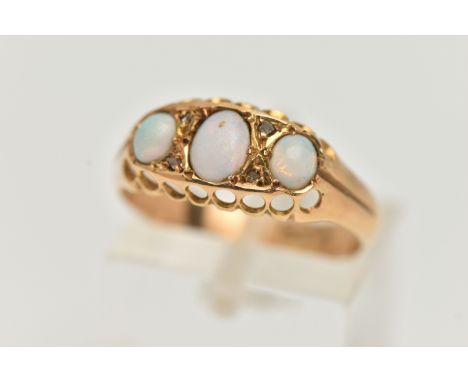 AN EARLY 20TH CENTURY OPAL AND DIAMOND RING, set with three oval opal cabochons, interspaced with four diamond chips, open wo