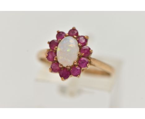 A 9CT GOLD OPAL AND RUBY CLUSTER RING, the central oval opal cabochon within a circular cut ruby surround, with 9ct hallmark 