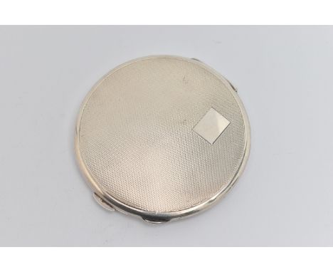 A SILVER COMPACT, circular form, engine turned pattern with vacant cartouche, push button clasp, removable powder compartment