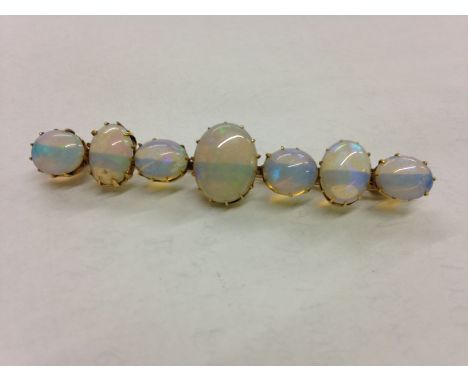 A gold and opal bar brooch, the central oval opal 12mm x 10mm, flanked by three graduating opals on each side, 5.2g in total