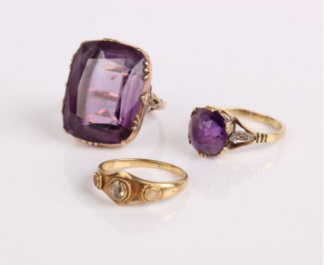 A gold and amethyst dress ring, another amethyst ring and a gold coloured ring (3) 