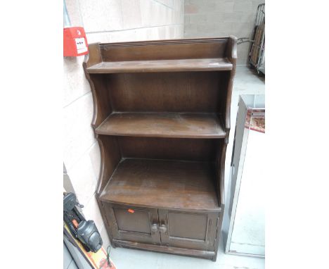 An Ercol style bookshelf with cupboard under