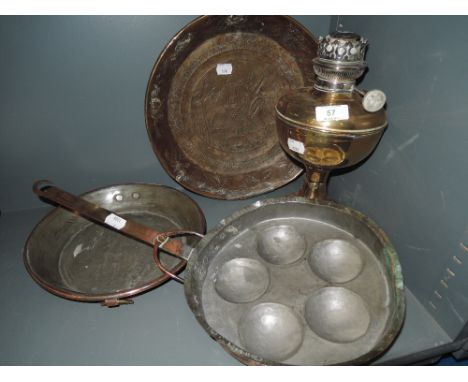 A brass lamp and copper pans