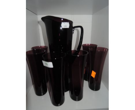 A water jug and glasses in ruby glass