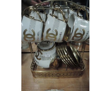 A gilt tea service marked Chanel on stand6 CUPS AND SAUCERS AND A TEAPOT, ALL WORN CONDITION