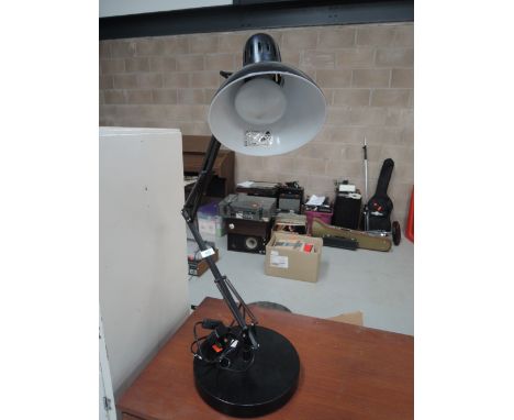 An angle poise lamp in black with oversized base