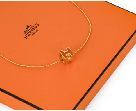 A Silver Gilt Pendant on Chain, by Hermès, the cube-shaped pendant depicting 'H' enamelled in orange, on a snake link chain, 