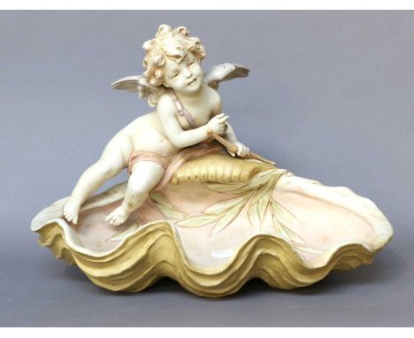 A Large Royal Dux Figural Bowl, Cupid amongst foliage mold number 2482, 38cm wide; together with a pair of Royal Dux figures 