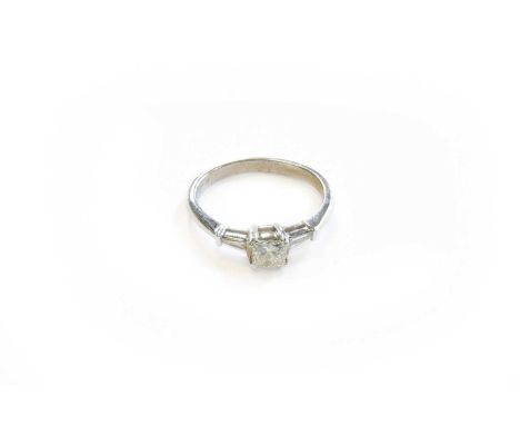 A Diamond Solitaire Ring, the princess cut diamond in a white claw setting, to tapered baguette cut diamond set shoulders, to