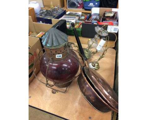 A chandelier, lamp and a bed warmer