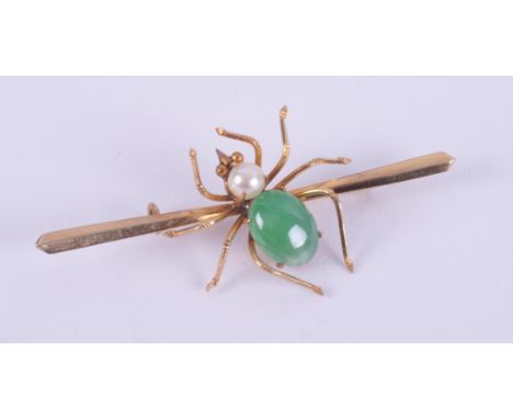A 14ct spider brooch set with an oval cabochon cut jade measuring approx. 10mm x 7.5mm and a round white pearl, with pin &amp